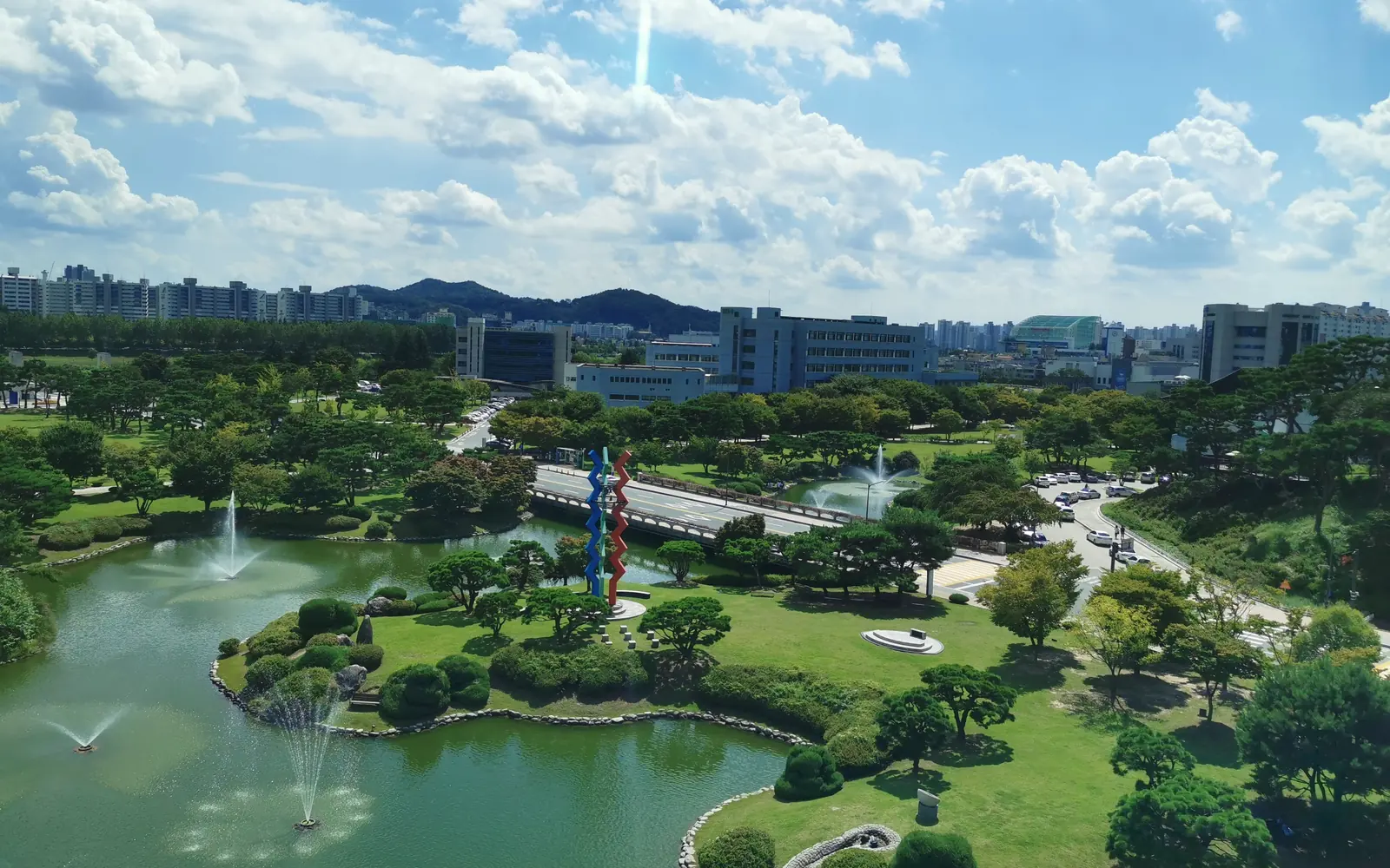 Кампус KAIST в Тэджоне: пруд с фонтанами, сосны и учебные корпуса